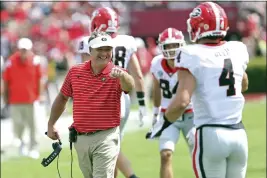  ?? ARTIE WALKER JR. — THE ASSOCIATED PRESS ?? Georgia head coach Kirby Smart congratula­tes tight end Oscar Delp (4) after he scored a touchdown during the second half of an NCAA college football game against South Carolina on Saturday in Columbia, S.C.