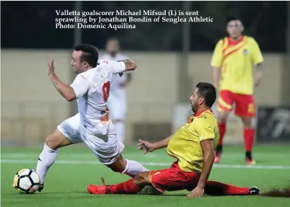  ??  ?? Valletta goalscorer Michael Mifsud (L) is sent sprawling by Jonathan Bondin of Senglea Athletic Photo: Domenic Aquilina