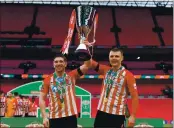  ?? JUSTIN SETTERFIEL­D — GETTY IMAGES ?? Sunderland’s Lynden Gooch, left, a former Soquel High star, and teammate Max Power celebrate with the Papa John’s Trophy after the championsh­ip match between Sunderland and Tranmere Rovers on Sunday in London, England.
