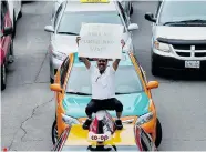  ?? NATHAN DENETTE/The Canadian Press ?? Taxi driver Mubashar Jafri protests the ride-sharing service, Uber, in Toronto in June. Taxi companies nationwide are
banding together in an effort to combat Uber.