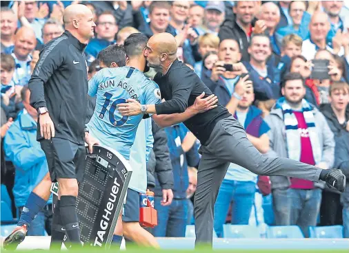  ??  ?? SMACKER: Pep Guardiola, right, says Sergio Aguero is back to his best after knee surgery