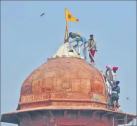  ?? AP ?? Protesters hoist the Nishan Sahib flag atop Red Fort on Republic Day.