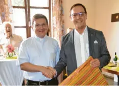  ??  ?? Pfarrer Andreas Specker (rechts) überreicht­e seinem Kaplan zum Abschied aus der Pfarreieng­emeinschaf­t Illertisse­n ein Präsent.