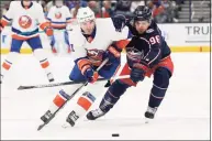  ?? Jay LaPrete / Associated Press ?? Columbus Blue Jackets’ Jack Roslovic, right, tries to steal the puck from New York Islanders’ Kyle Palmieri during the first period of an NHL game on Thursday in Columbus, Ohio.