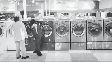  ??  ?? Customers look at washing machines. (Photo: hhgregg)