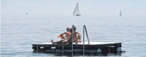  ?? FOTO: FELIX KÄSTLE/DPA ?? Spaß am Bodensee: Die Badenden, wie hier auf einem Floß des Strandbads Friedrichs­hafen, genießen die Hitze.