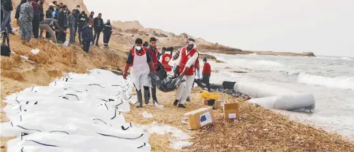  ??  ?? Des employés du Croissant-Rouge cordent les corps sur la plage libyenne, lundi, près de Zawiya. − Associated Press: FICR/Mohannad Karima