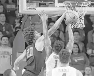  ?? Sue Ogrocki / Associated Press ?? Texas forward Jericho Sims (20) leaves Oklahoma guard Rashard Odomes (1) with a feeling of rejection in the first half of the Longhorns’ win Saturday in Norman, Okla.