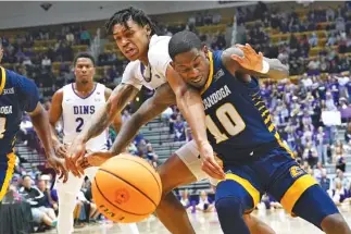  ?? AP PHOTO/KATHY KMONICEK ?? Furman forward Tyrese Hughey and UTC guard Dalvin White (10) battle for a loose ball Monday during the SoCon championsh­ip game in Asheville, N.C.