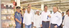  ??  ?? Ameer (second right) showing some of the halal goods displayed in Mydin hypermarke­t in Sandakan.