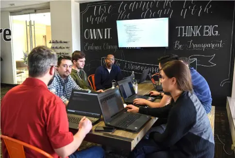  ?? — WP- Bloomberg photos ?? Employees of Amify have a meeting at the company’s Alexandria headquarte­rs.