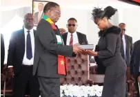  ?? - ?? President Mnangagwa hands over the national flag to Paida, daughter to the late national hero Colonel (Retired) Kenny Ridzai Mabuya at the National Heroes Acre in Harare yesterday. Picture: Kudakwashe Hunda