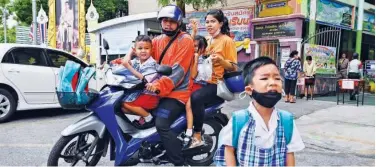  ?? Agence France-presse ?? Parents pick up their children on a motorcycle from school in Bangkok.