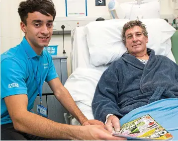  ??  ?? Doing his bit: Max Whitfield, 18, with Norman Gooldring, 67 at Frimley Park Hospital