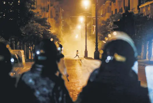  ??  ?? A Lebanese protester runs to avoid tear gas amid clashes with security forces in downtown Beirut, Lebanon, Aug. 11, 2020. (AFP Photo)