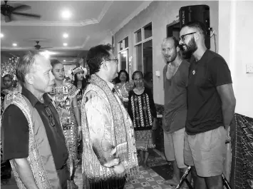  ??  ?? Nanta speaks to two visitors from London who joined the Gawai Dayak celebratio­n at the longhouse. Behind him is Tuai Rumah William Unchat.