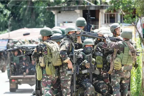  ??  ?? Soldiers ride a military vehicle on the outskirts of Marawi city, southern Philippine­s. (AFP)