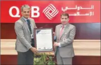  ?? ?? QIIB Chief Risk Officer Mohammad Jamil Ahmad Hamad was handed over the certificat­e by SISA Vice President Ramakrishn­an Balagopal during a ceremony held at the bank’s headquarte­rs at the Grand Hamad Street.