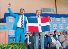  ?? MIKE GROLI/AP PHOTO ?? Hall of Fame inductee Pedro Martinez, left, holds the flag of the Dominican Republic with countryman and fellow Hall of Famer Juan Marichal during the induction ceremony Sunday in Cooperstow­n, N.Y.