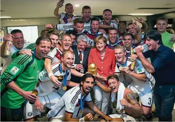  ??  ?? Beim WM-Titelgewin­n 2014 in Brasilien feierte Bundeskanz­lerin Angela Merkel in der Kabine der DFB-Helden kräftig mit. Aktuell hat sie aber ganz andere Sorgen als den Fußball in Deutschlan­d.