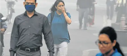  ?? Picture: AFP ?? MOST POLLUTED CITY: Indian people walk on a street as heavy smog covers Delhi yesterday. The city shut all primary schools as pollution levels hit nearly 70 times the World Health Organisati­on safe level