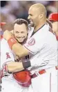  ?? Stephen Dunn Getty Images ?? DANIEL NAVA gets a hug from Albert Pujols after the Angels rallied in the ninth to win.