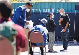  ??  ?? Deputy Public Defender Mercedes Cook speaks with Randall Gibson, 39, right, outside the Redondo Beach Police Department.