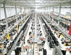  ?? INA FASSBENDER/DPA/AFP ?? Employees work at the distributi­on centre of US online retail giant Amazon in Dortmund, Germany.