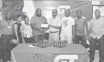  ??  ?? Coach of Den Amstel and tournament host O’Neil Heywood (3rd from left), receiving the sponsorshi­p cheque from Banks DIH Limited GT Beer Brand Manager Jeffrey Clement in the presence of company executives and members of Den Amstel FC