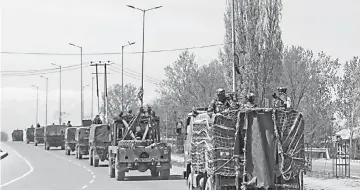  ??  ?? Indian security forces are transporte­d in a convoy on a closed highway on the outskirts of Srinagar. — AFP photo