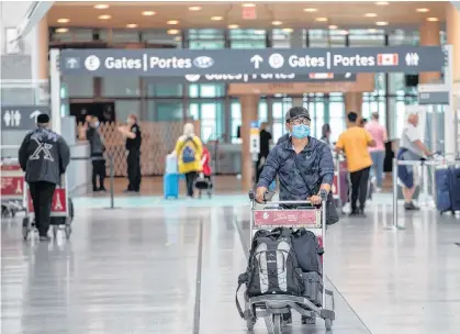  ?? REUTERS ?? A passenger wears a mask, which is now mandatory as a Healthy Airport initiative is launched for travel, taking into account social distancing protocols to slow the spread of the coronaviru­s disease (COVID-19) at Toronto Pearson Internatio­nal Airport in Ontario on June 23, 2020.