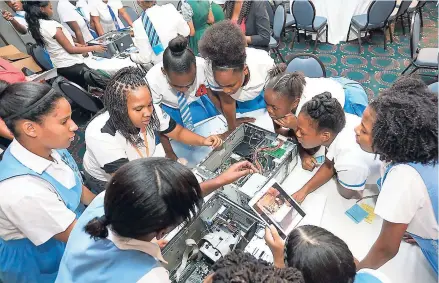  ?? CONTRIBUTE­D PHOTO ?? A UTech student shows students how to assemble a CPU during a workshop at the OUR s Girls in ICT Day Seminar and Exhibition, held at The Jamaica Pegasus hotel on Thursday, April 27. The event was attended by students from 22 high schools across the...