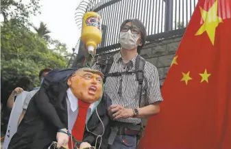  ?? Kin Cheung / Associated Press ?? Small groups of Beijing supporters marched to the U.S. Consulate in Hong Kong to protest President Trump’s series of measures aimed at China as a rift between the two countries grows.