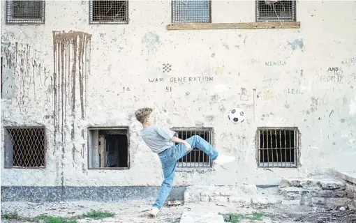  ?? COLIN DAVEY/GETTY IMAGES ?? A boy playing with a football in front of a blood-soaked wall in Zadar during the Croatian War of Independen­ce, November 1994