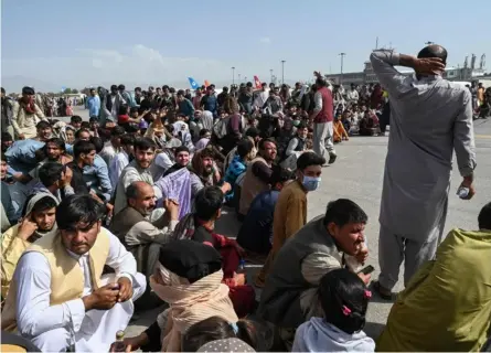  ?? AFP ?? Una multitud de afganos tomó la pista del aeródromo de Kabul. Algunos, incluso, intentaron enganchars­e a las partes laterales y a las ruedas de un avión militar estadounid­ense a punto de despegar.