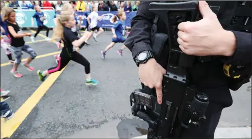  ?? ?? Armed police officers on patrol as thousands of defiant runners and spectators turn out for the Great Manchester Run, following the terror attack at the Manchester Arena in the city one week ago