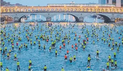  ?? THE NEW YORK TIMES ?? Prueba piloto. Aficionado­s al paddle surf navegaron por el Sena, pero hubo muchas quejas.