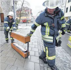  ?? FOTO: FELIX KÄSTLE/DPA ?? Bei dem Großbrand in der Kirche St. Jodok retten die Einsatzkrä­fte am Samstag auch Gebet- und Gesangbüch­er.