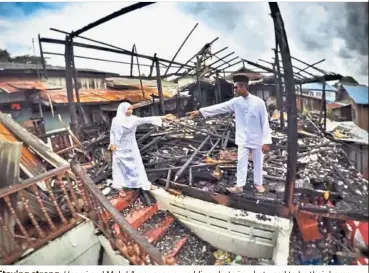  ??  ?? Staying strong: Hasmi and Mohd Amer snap a wedding photo in what used to be their home which was razed by fire.