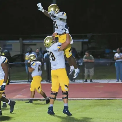  ?? JOHN MCCALL/SOUTH FLORIDA SUN SENTINEL ?? St. Thomas Aquinas offensive lineman Ryan Mickow hoists running back Jordan Lyle into the air after scoring a touchdown against Dillard during the first half on Friday in Fort Lauderdale.