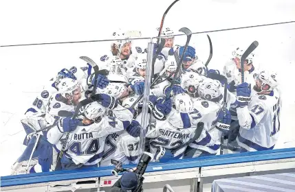  ??  ?? VILLAIN TO HERO: Tampa Bay’s Kevin Shattenkir­k is congratula­ted by his teammates after scoring the gamewinnin­g goal during the first overtime period.