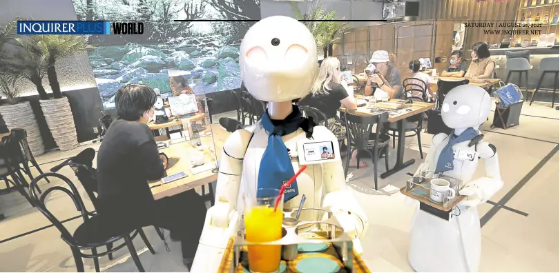  ?? —PHOTOS BY AFP ?? JUST LIKE BEING THERE A robot controlled by a person with disability working hundreds of kilometers away at home delivers drinks to customers at Tokyo’s Dawn Cafe on Tuesday.