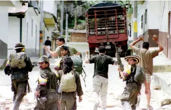  ??  ?? Miembros de la guerrilla, durante la toma de tres policías como rehenes en la población de Dolores, provincia de Tolima, en noviembre de 1999. Entre 1970 y 2010, las FARC secuestrar­on a unas 40 mil personas.