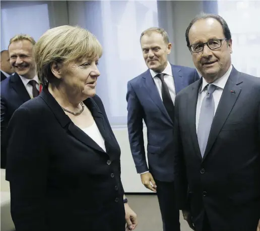  ?? Olivier Hoslet / The Associat ed Press ?? German Chancellor Angela Merkel, centre left, speaks with French President Francois Hollande, right, in Brussels.
