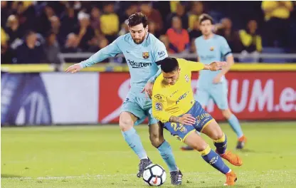  ?? AP ?? El atacante argentino Lionel Messi (izquierda) lucha por el balón con Ximo Navarro de Las Palmas en la Liga española, ayer.