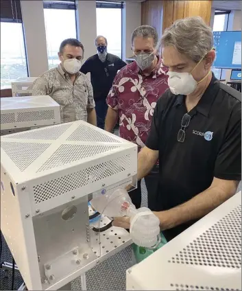  ?? County of Maui / BRIAN PERRY photo ?? Dan O’Connell of HNu Photonics demonstrat­es how the bridge ventilator­s work to Maui County Mayor Michael Victorino and Managing Director Sandy Baz on Wednesday.