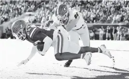  ?? JAMES GILBERT Getty Images ?? Florida’s Rashad Torrence II lunges forward after intercepti­ng a pass in the second quarter, one of the few brights spots for UF against Georgia in Jacksonvil­le on Saturday.