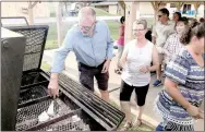  ?? Photo submitted ?? Wayne and Colleen Whitney, members of St. Theodore Episcopal Church, drop pieces of the mortgage in a fire pit Sunday, Sept. 24, at the pavilion at Riordan Hall. The church members retired the mortgage in a ceremony marking the end of a more-than...
