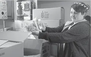  ?? Staff photos by Neil Abeles ?? right
Atlanta Library volunteer Abby
Amos shows the food she will help distribute during the library’s’s associatio­n with the East Texas Food Bank and its
summer lunch program.