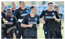  ??  ?? Englishman abroad: Thoughts of home were on Jamie Carragher’s mind after a draw with Algeria (main picture) or training (left), in 2010